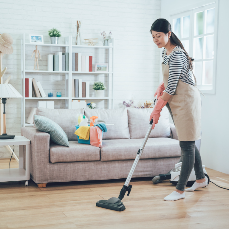 A happy person using a vacuum cleaner